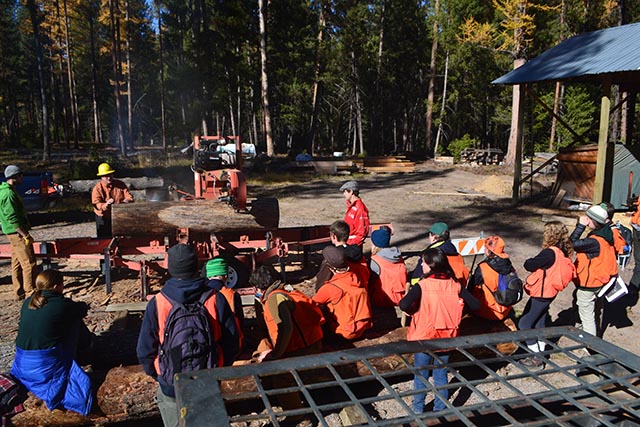 Students watch a demonstration of the sawmill at Lubrecht with professor of wood science Ed Burke.